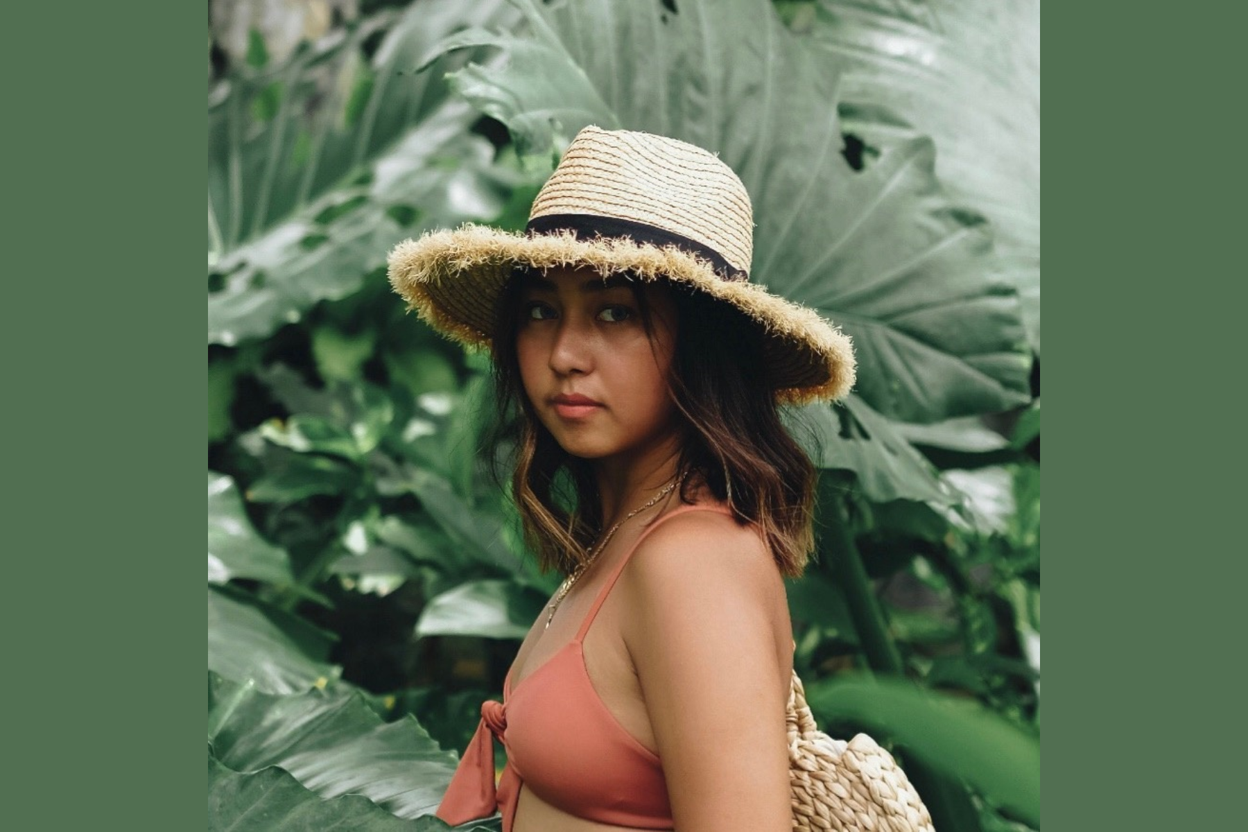 Andie Javelosa in a simple hat in a leafy setting